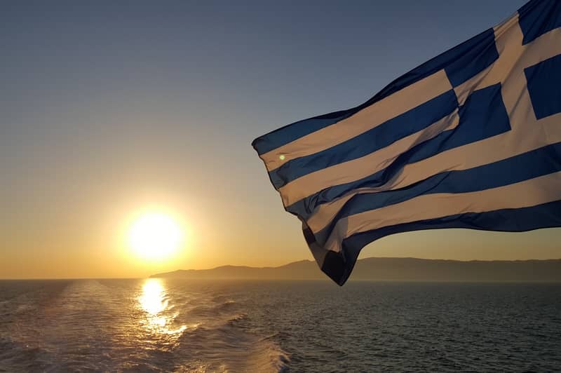 Photographie du drapeau grec en mer, en ligne sur Pixabay : https://pixabay.com/fr/photos/drapeau-grecque-vacances-mer-2390260/