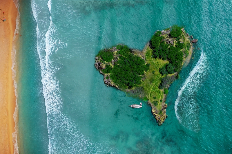 Photographie d'une île en forme de cœur, en ligne sur Pixabay :  https://pixabay.com/fr/photos/%c3%aele-coeur-ocean-lagune-plage-mer-3542290/